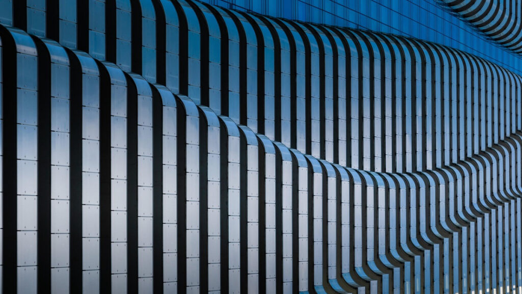 Abstrakte Gebäudefassade mit wiederholenden Strukturen als Symbol für Architekturpattern, DRY-Prinzip und moderne Softwarearchitektur